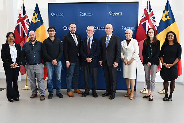 A total of $930,000 in new provincial investments in local research projects was announced on Monday. Attending the event were, from left: Farhana Zulkernine (Computing); Michael Rainbow (Mechanical and Materials Engineering); Bhavin Shastri (Physics); Kingston and Thousand Islands MPP Ian Arthur; Principal and Vice-Chancellor Patrick Deane; Leeds-Grenville-Thousand Islands and Rideau Lakes MPP Steve Clark; Interim Vice-Principal (Research) Kimberly Woodhouse; Laura Wells (Chemical Engineering); and Sheela Abraham (Biomedical and Molecular Sciences). (University Communications)